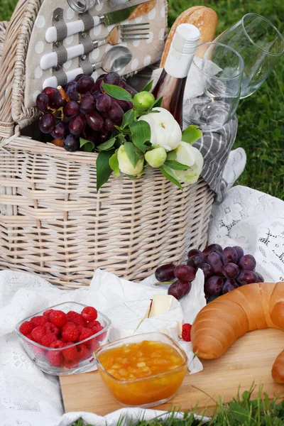 Manta Picnic Con Sabrosa Comida Flores Cesta Sidra Hierba Verde — Foto de Stock