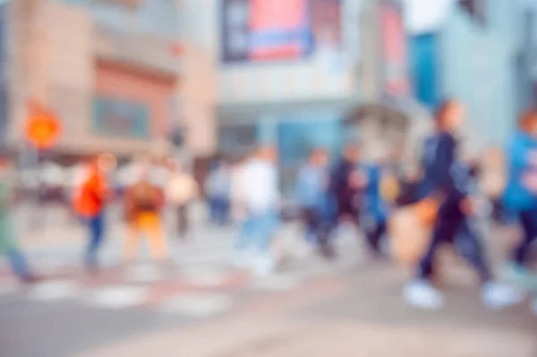 People crossing street in city, blurred view