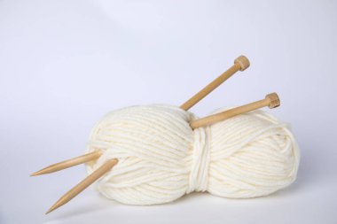 Yumuşak yün iplik ve beyaz arka planda örgü iğneleri