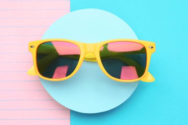 Renk arkaplanı ve üst görünümü olan şık güneş gözlükleri