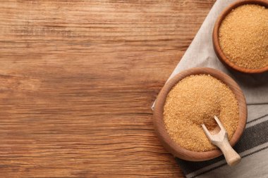 Tahta masadaki kaselerde esmer şeker, düz uzanmış. Metin için boşluk