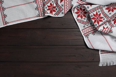 Beautiful rushnyk on wooden table, top view with space for text. Ukrainian national embroidery
