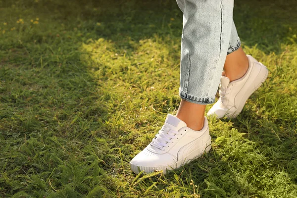 Woman Jeans White Shoes Walking Green Grass Closeup Space Text — 스톡 사진