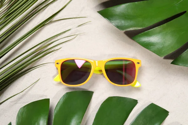 Stylish Sunglasses Tropical Leaves Sand Flat Lay — Stock fotografie