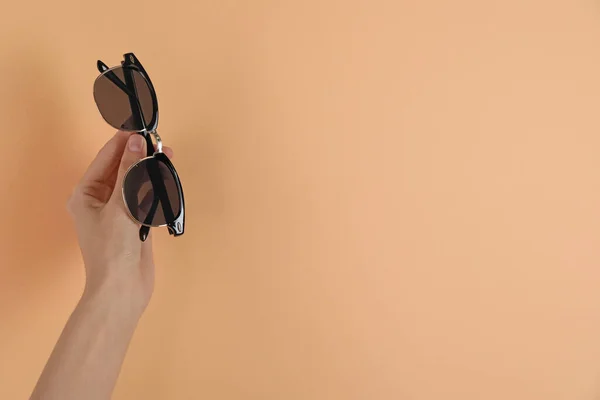 Woman Holding Stylish Sunglasses Pale Orange Background Closeup Space Text — 스톡 사진