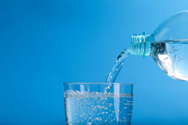 Заливаючи Содову Воду Пляшки Склянку Світло Блакитному Фоні Крупним Планом — стокове фото