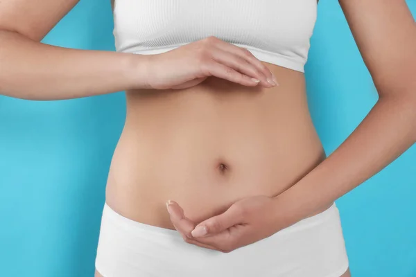 Woman Underwear Holding Something Her Belly Light Blue Background Closeup — Fotografia de Stock