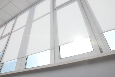 Beyaz jaluzili geniş pencere. Kapalı kapılar, düşük açı.