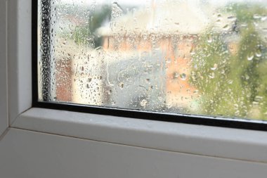 Yağmurlu bir günde ıslak pencere, yakın plan. İçeriden görüntüle