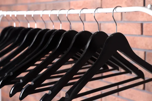 Cabides Roupas Pretas Rack Perto Parede Tijolo Vermelho Close — Fotografia de Stock