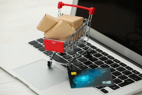Online Bezahlkonzept Kleiner Warenkorb Mit Bankkarte Boxen Laptop Nahaufnahme — Stockfoto