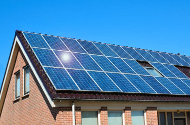 Çatıda kurulu güneş panelleri olan bir bina. Alternatif enerji kaynağı