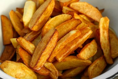Lezzetli kızarmış patates dilimli metal kase, yakın plan.