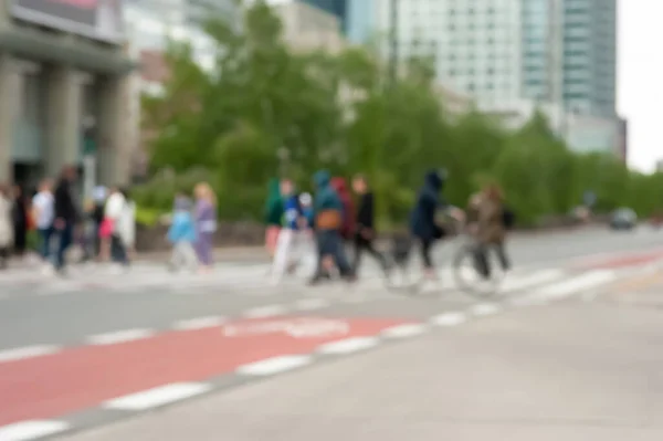 People crossing street in city, blurred view