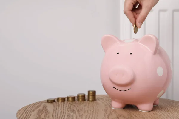 Woman Putting Coin Piggy Bank Heating Radiator Closeup Space Text — Photo