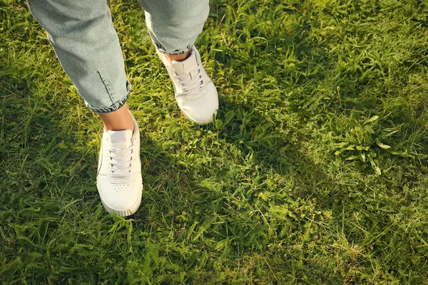 Woman Jeans White Shoes Walking Green Grass Closeup Space Text — Stock Photo, Image