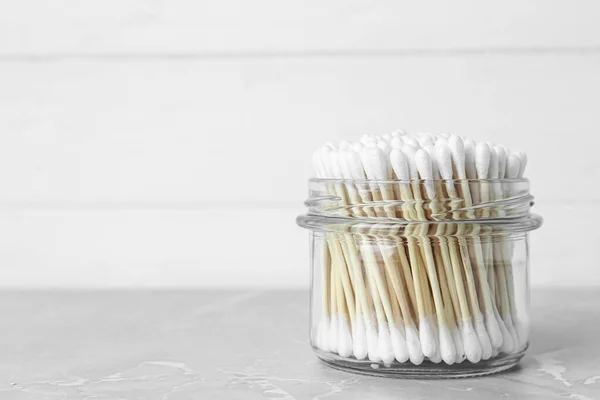 Many Cotton Buds Glass Jar Light Grey Marble Table Space — Foto de Stock