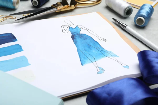 Drawing of dress on table, closeup. Designer's workplace