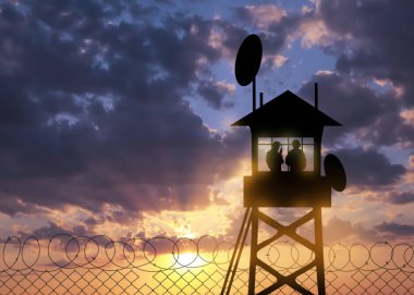 Silhouettes of border guards at post outdoors in early morning