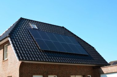 Çatıda kurulu güneş panelleri olan bir bina. Alternatif enerji kaynağı