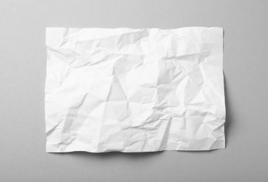 Gri arkaplan üzerine beyaz buruşuk kağıt yaprağı, üst görünüm