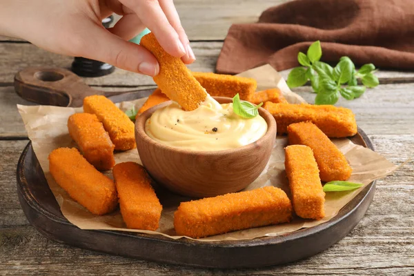 Woman Dipping Delicious Chicken Nuggets Cheese Sauce Wooden Table Closeup — 图库照片