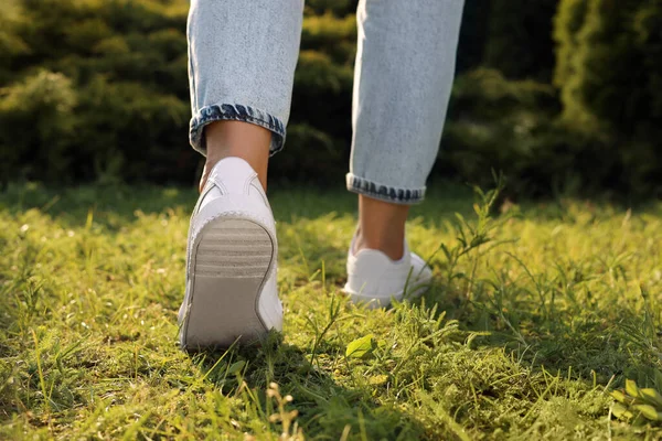 Woman Jeans White Shoes Walking Green Grass Closeup — Φωτογραφία Αρχείου