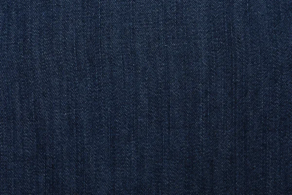 Texture of dark blue jeans as background, closeup