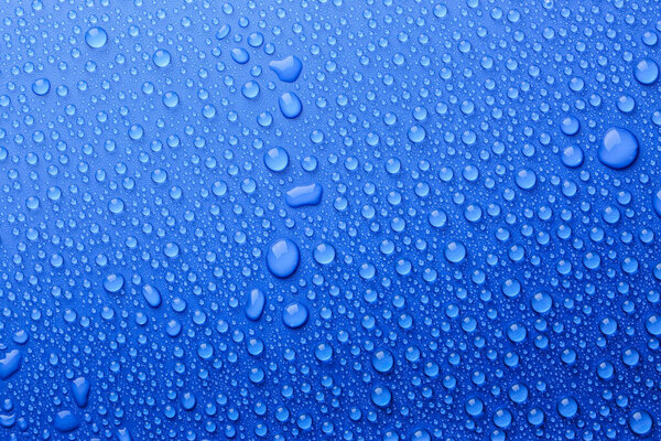Капли воды на голубом фоне, вид сверху

