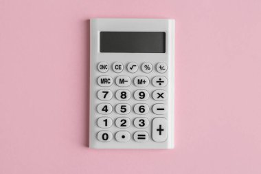 White calculator on pink background, top view