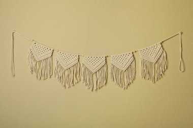 Bej duvarda asılı güzel, büyük bir makrome. Dekoratif öge