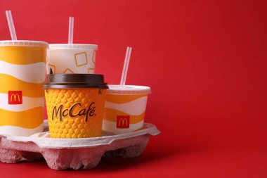 MYKOLAIV, UKRAINE - 12 Ağustos 2021: Kırmızı arka planda soğuk ve sıcak McDonald 's içecekleri