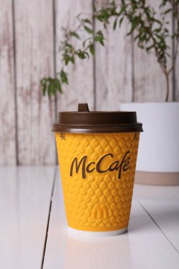 MYKOLAIV, UKRAINE - 12 Ağustos 2021: Sıcak McDonald 's içeceği beyaz ahşap masada