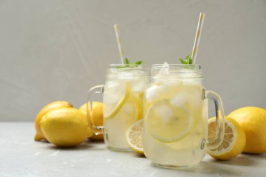 Nane aromalı doğal limonata ve açık gri mermer masada taze meyveler. Yaz ferahlatıcı içecek