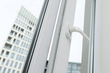 Open window with white plastic frame indoors, low angle view