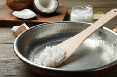 Hindistancevizi yağlı tava ve ahşap masa üzerinde ahşap spatula, yakın plan. Sağlıklı yemek.