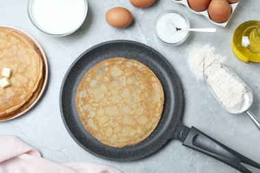 Flat lay composition with thin pancakes on grey marble table