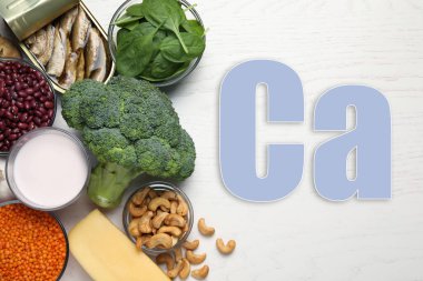 Beyaz ahşap masa üzerinde kolayca emilebilen yüksek miktarda kalsiyum içeren farklı taze ürünler.