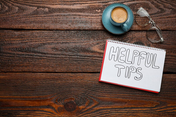 Notebook with phrase Helpful Tips, cup of coffee and eyeglasses on wooden table, flat lay. Space for text