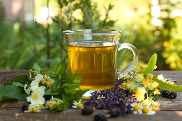 Cup Hot Aromatic Tea Different Fresh Herbs Wooden Table Outdoors — Foto Stock