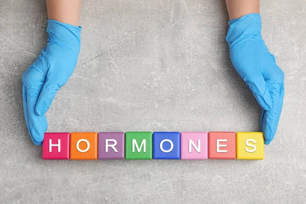 Dokter Maakt Woord Hormonen Met Kleurrijke Blokjes Aan Grijze Tafel — Stockfoto