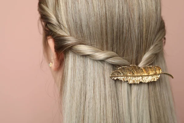 ピンクの背景に美しい金の髪のクリップを持つ若い女性 — ストック写真