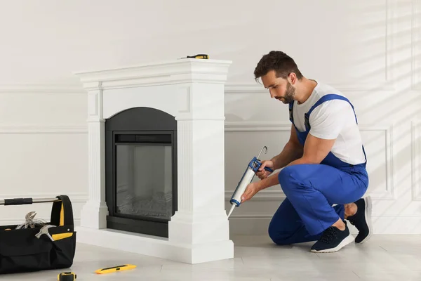 Professional Technician Sealing Electric Fireplace Caulk White Wall Room — Stockfoto