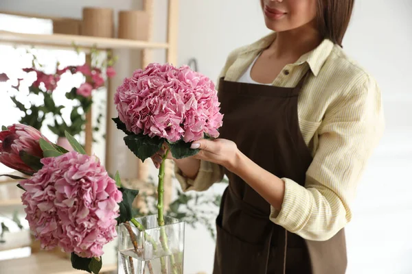 Florist with beautiful flowers in workshop, closeup