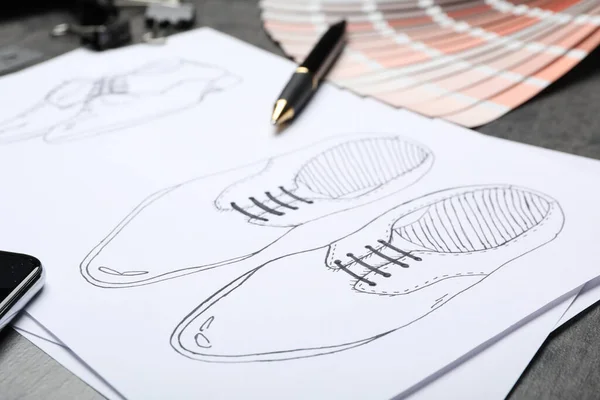 Drawing of shoes on table, closeup. Designer\'s workplace