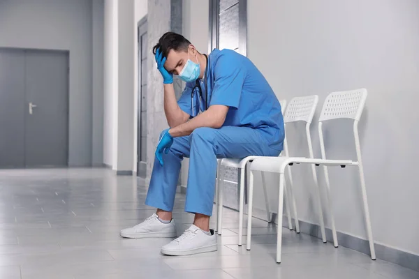 Exhausted Doctor Sitting Chair Hospital Hallway — Stock Fotó
