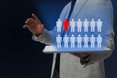 Çalışanların işten çıkarılıp çıkarılmayacağına karar vermek. Koyu arkaplanda tabletli adam, yakın plan