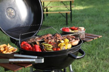 Barbekü ızgarasında lezzetli et ve sebzeler.