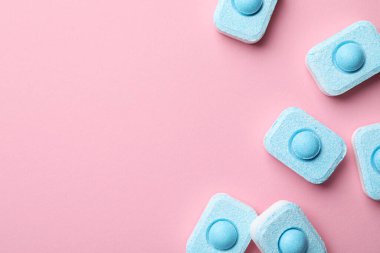 Su yumuşatıcı tabletler pembe arka planda, düz yerde. Metin için boşluk