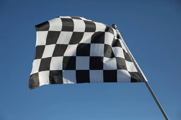 Checkered finish flag on light blue background